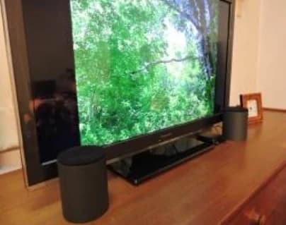 Speakers standing upright in front of the television